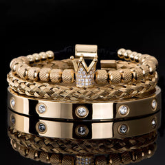 Luxurious gold bracelets featuring braided designs and a crown charm, highlighting elegance and craftsmanship.